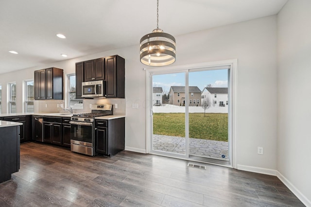 kitchen with light countertops, dark wood-style floors, and stainless steel appliances