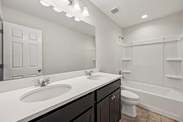 bathroom featuring double vanity, toilet, visible vents, and a sink