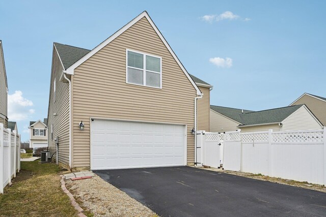 6741 Bigerton, Canal Winchester, OH 43110 - view of side of home featuring an attached garage, driveway, fence, and central AC unit