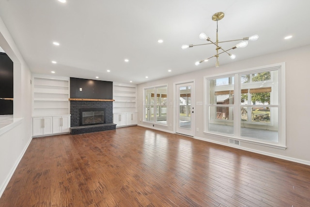 unfurnished living room featuring hardwood / wood-style flooring, a fireplace, and a wealth of natural light