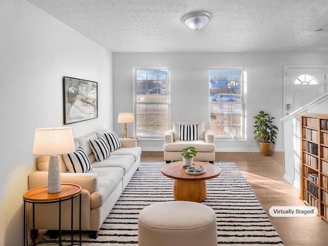 living room featuring wood finished floors, baseboards, and a textured ceiling