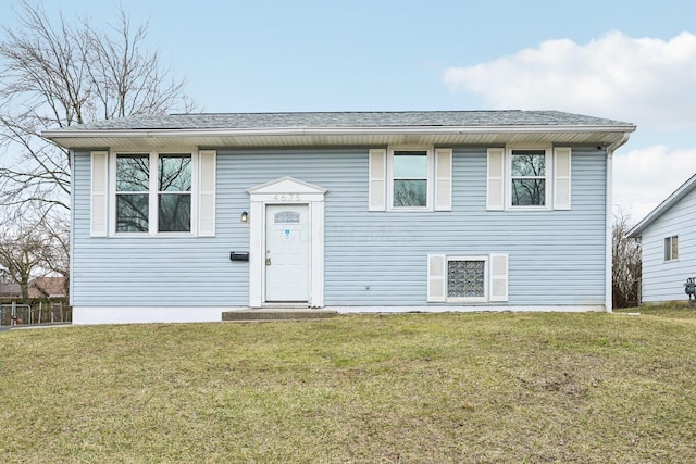 bi-level home with a front lawn and roof with shingles