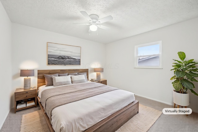 bedroom with light carpet, ceiling fan, a textured ceiling, and baseboards