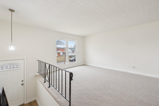 interior space with stairway, baseboards, and a textured ceiling