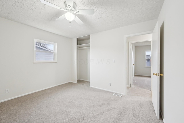 unfurnished bedroom with visible vents, a textured ceiling, baseboards, and carpet floors