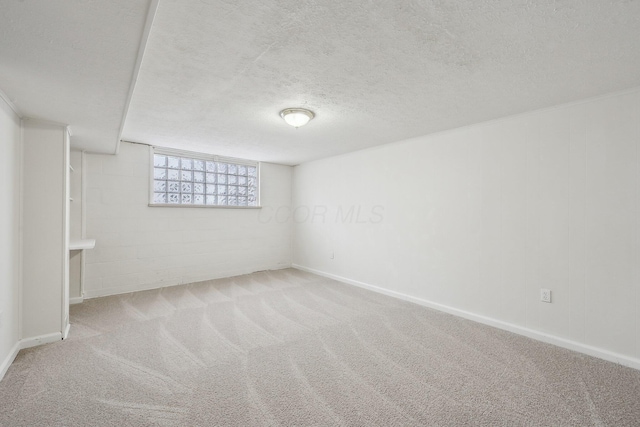 unfurnished room featuring concrete block wall, a textured ceiling, and carpet flooring