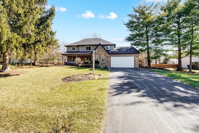 view of front of property featuring a front yard, an attached garage, fence, and driveway