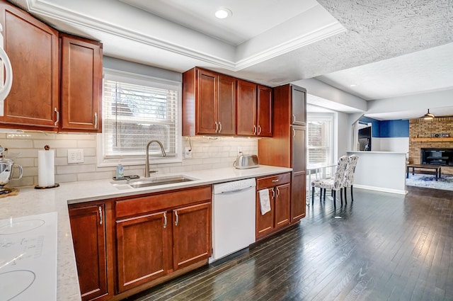 kitchen featuring a sink, backsplash, dark wood finished floors, white appliances, and light countertops