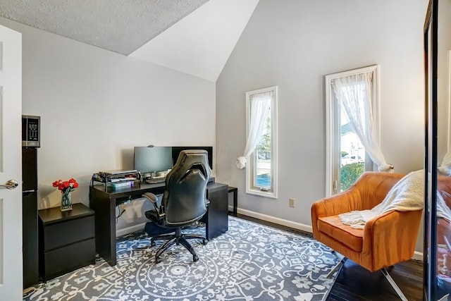 office space with baseboards, lofted ceiling, a textured ceiling, and wood finished floors