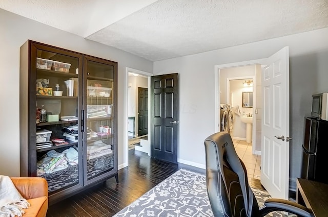 office space featuring baseboards, wood finished floors, independent washer and dryer, and a textured ceiling