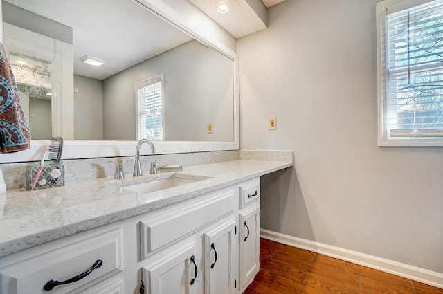 bathroom with vanity, baseboards, and wood finished floors