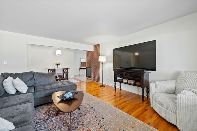 living room with a fireplace, wood finished floors, and baseboards