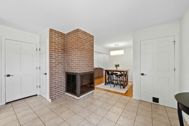 living area featuring light tile patterned floors, a fireplace, and a wall mounted AC