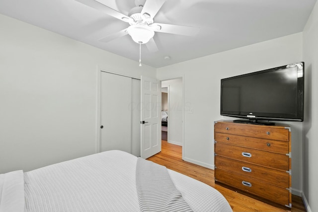 bedroom with a ceiling fan, baseboards, a closet, and light wood finished floors