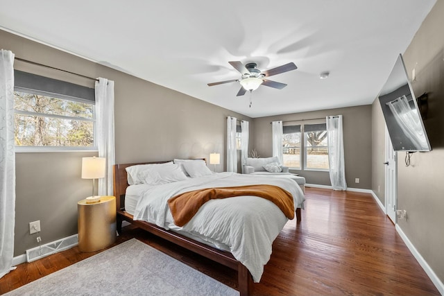 bedroom featuring visible vents, baseboards, wood finished floors, and a ceiling fan