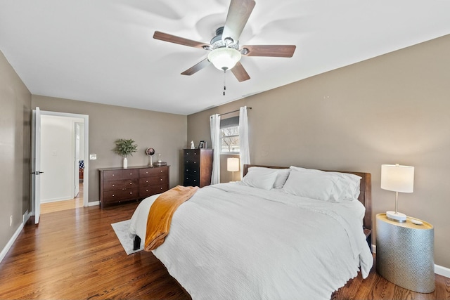 bedroom with baseboards, wood finished floors, and a ceiling fan