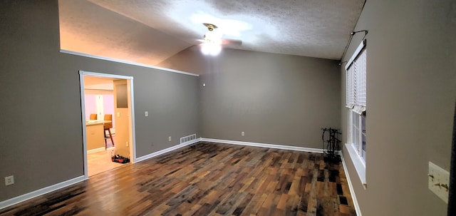 interior space with visible vents, a textured ceiling, wood finished floors, baseboards, and lofted ceiling