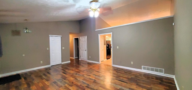 interior space featuring visible vents, baseboards, lofted ceiling, wood finished floors, and black fridge with ice dispenser