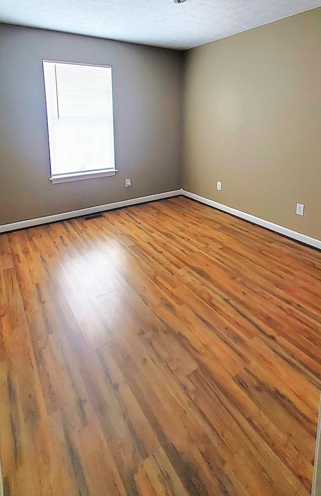 empty room featuring baseboards and wood finished floors