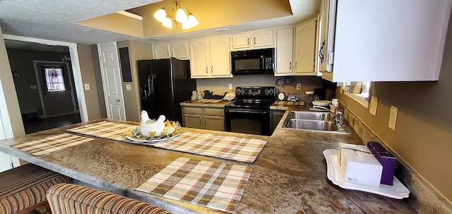 kitchen with black appliances, a sink, a peninsula, white cabinets, and an inviting chandelier