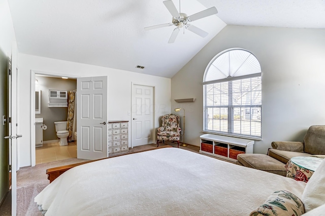 bedroom featuring visible vents, connected bathroom, carpet, vaulted ceiling, and a ceiling fan