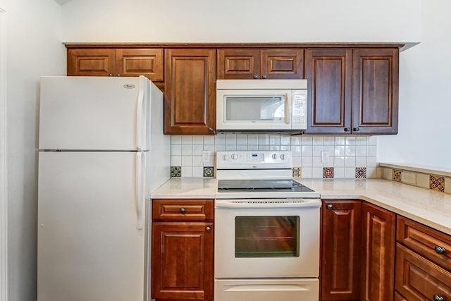 kitchen with white appliances, light countertops, and backsplash