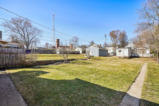 view of yard with a storage shed, an outdoor structure, and fence