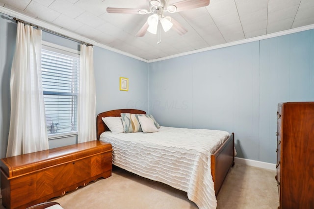 carpeted bedroom with a ceiling fan and ornamental molding