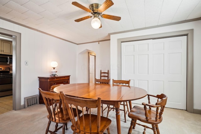 dining area featuring arched walkways, visible vents, light carpet, and crown molding