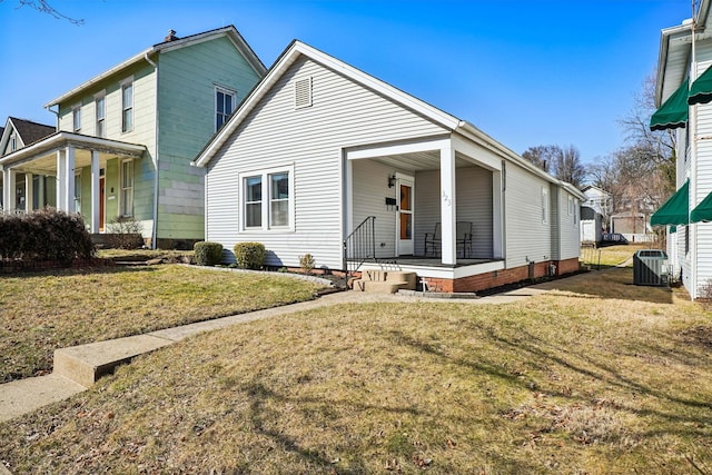 view of front of home with central air condition unit, a porch, and a front lawn