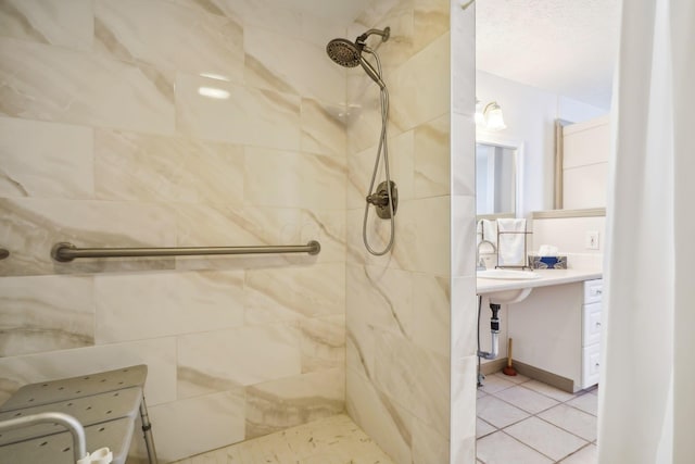 bathroom featuring a tile shower, tile patterned flooring, and vanity