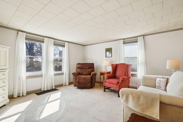 sitting room featuring ornamental molding, a wealth of natural light, and light carpet