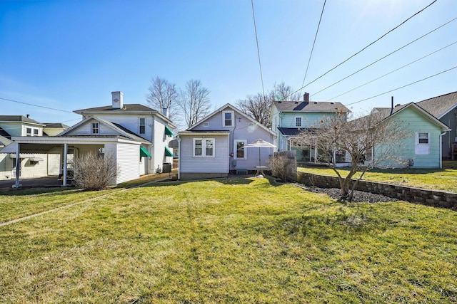 rear view of property featuring a yard