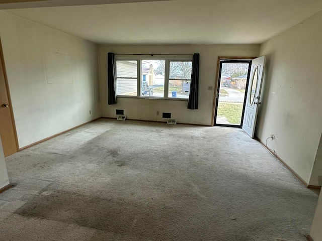 empty room with visible vents, baseboards, and carpet