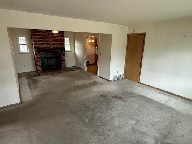 unfurnished living room with visible vents, a brick fireplace, and carpet