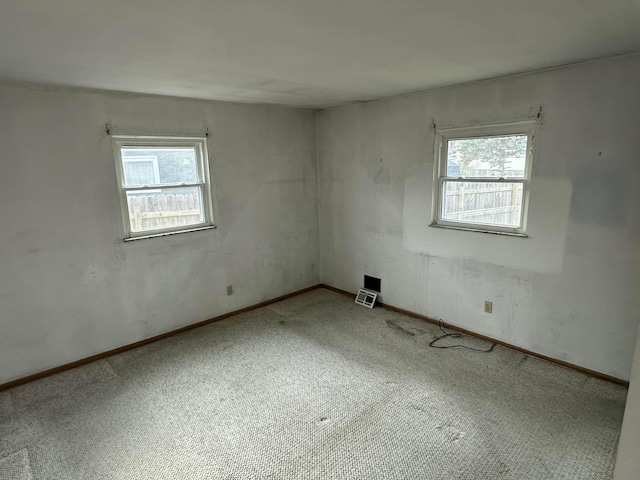 carpeted spare room featuring a healthy amount of sunlight