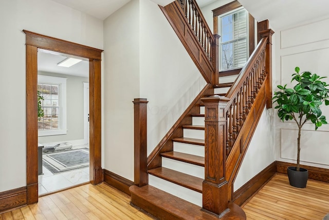 stairway with hardwood / wood-style floors and baseboards