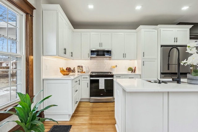 kitchen featuring light countertops, white cabinets, light wood-style floors, and stainless steel appliances