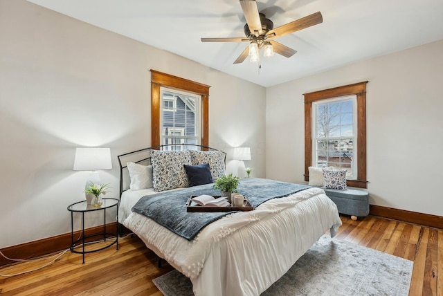 bedroom with a ceiling fan, baseboards, and wood-type flooring