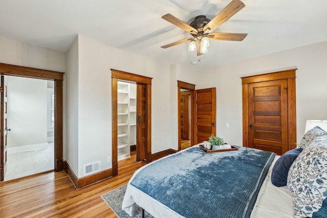 bedroom featuring visible vents, a closet, light wood-style floors, baseboards, and a spacious closet