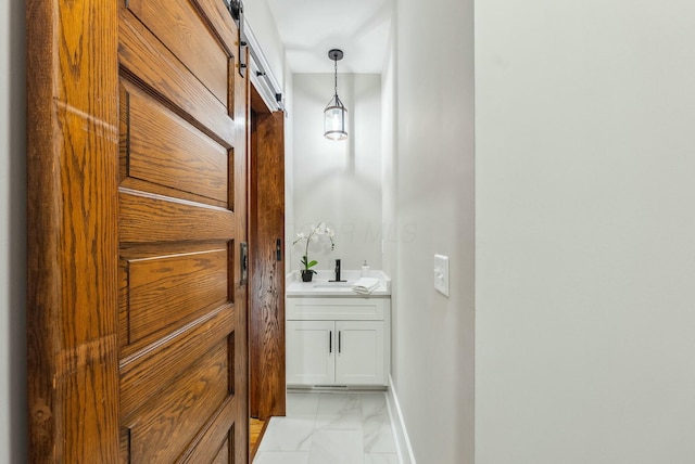 bathroom featuring baseboards, marble finish floor, and vanity