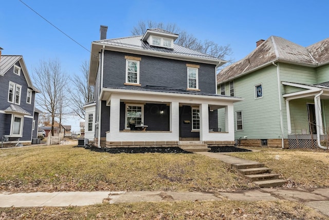 american foursquare style home with brick siding, a front lawn, central AC, covered porch, and metal roof