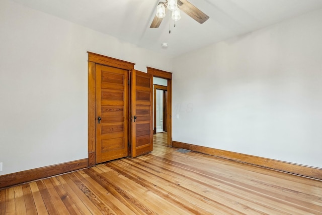 empty room featuring visible vents, baseboards, light wood-type flooring, and ceiling fan