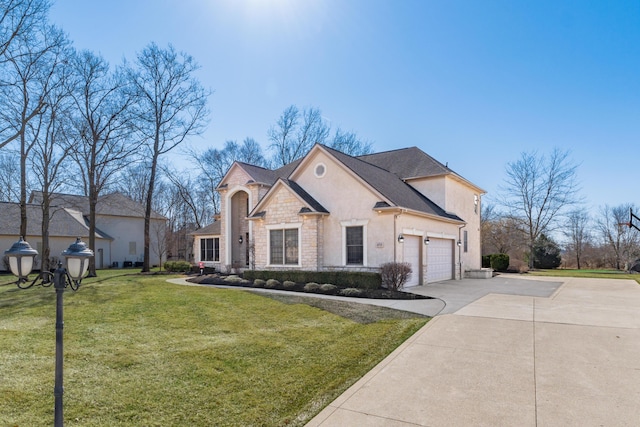 french provincial home featuring concrete driveway, a front yard, stucco siding, a garage, and stone siding