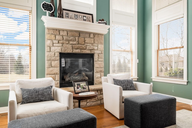 sitting room featuring baseboards, wood finished floors, and a fireplace