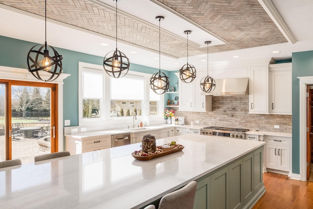 kitchen featuring dishwasher, wall chimney exhaust hood, light countertops, and a healthy amount of sunlight