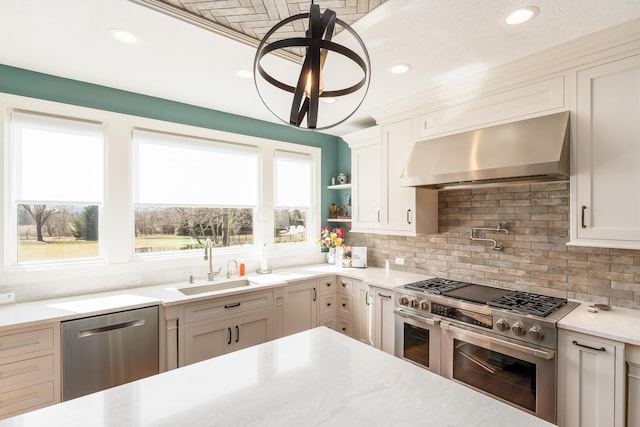 kitchen with a sink, wall chimney range hood, tasteful backsplash, and stainless steel appliances