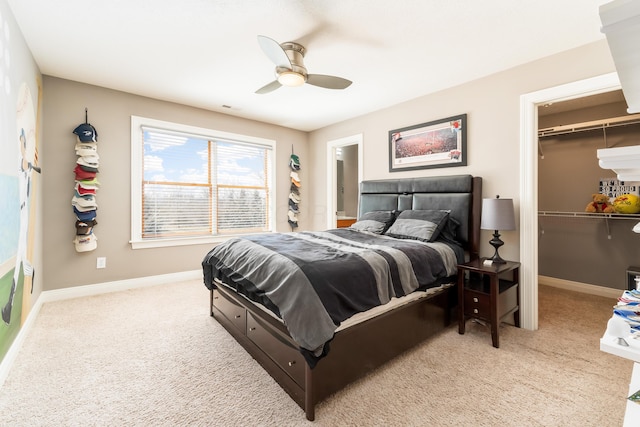 carpeted bedroom featuring visible vents, baseboards, ceiling fan, a closet, and a walk in closet