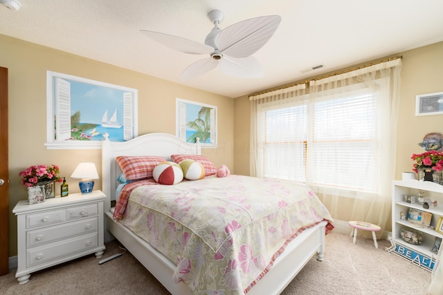 carpeted bedroom with baseboards, visible vents, and ceiling fan