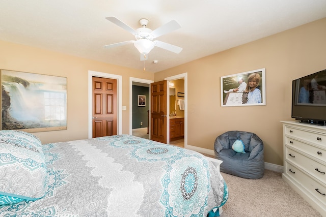 bedroom featuring baseboards, light colored carpet, ceiling fan, and ensuite bathroom